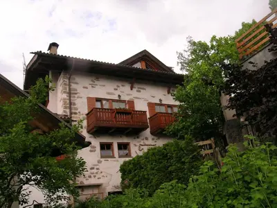 a white building with balconies on the side of it at B.& B. Corradini in Castello di Fiemme