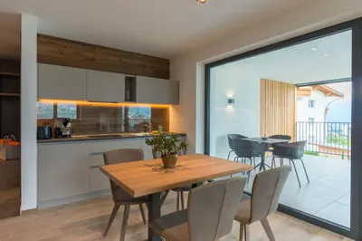 a kitchen and dining room with a wooden table and chairs at Moar am Ort in Schenna