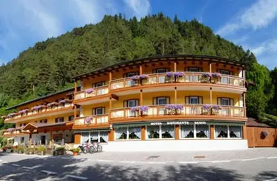 a large building with flowers on the balconies of it at Hotel Zanon in Ziano di Fiemme