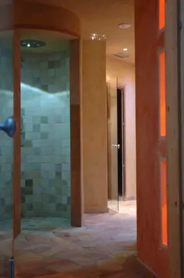 a bathroom with a glass door in a room at Hotel Bellaria in Predazzo