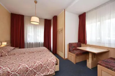 a hotel room with a bed and a desk at Hotel Bellaria in Predazzo