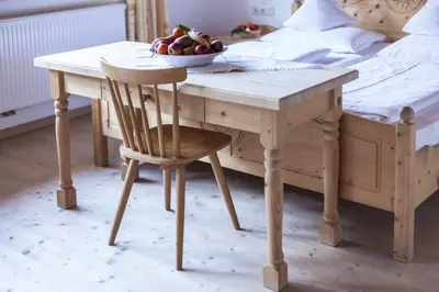 a table with a bowl of fruit on it next to a bed at Hotel Jägerhof in San Leonardo in Passiria