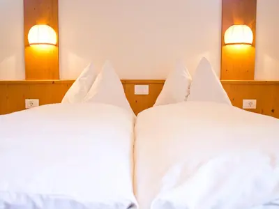 two beds in a room with white sheets at Schönblick OHG des Daum Tobias in Aldino