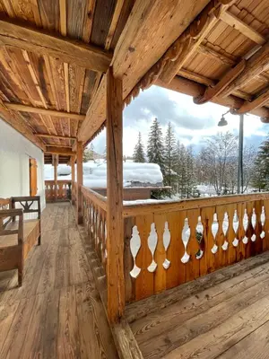 a wooden porch with a wooden railing with white hearts on it at Luxury Cortina in Cortina dʼAmpezzo