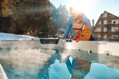 a man and a child looking at a pool of water at Ski Residence in San Martino di Castrozza