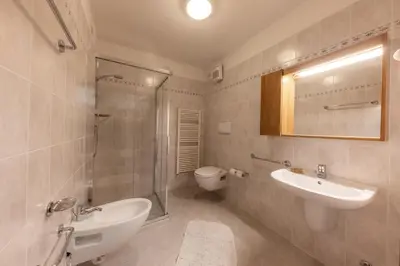a bathroom with a sink and a shower and a toilet at Ski Residence in San Martino di Castrozza