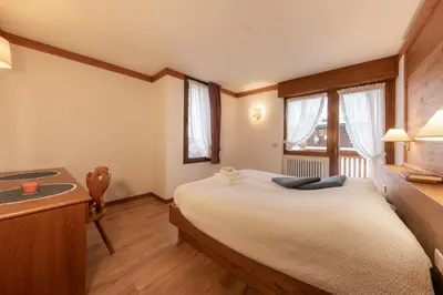 a bedroom with a large bed and a sink at Ski Residence in San Martino di Castrozza