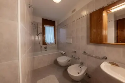a bathroom with a toilet and a tub and a sink at Ski Residence in San Martino di Castrozza