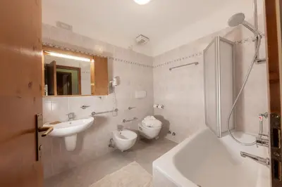 a bathroom with a sink and a tub and a toilet at Ski Residence in San Martino di Castrozza