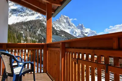 a deck with two chairs and a view of a mountain at Ski Residence in San Martino di Castrozza