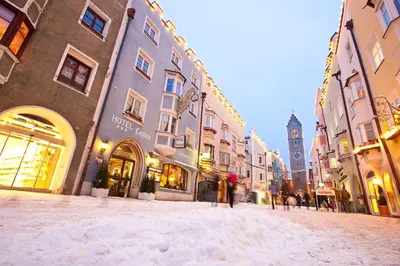 a snow covered street in a city with buildings at Posthotel Lamm in Vipiteno