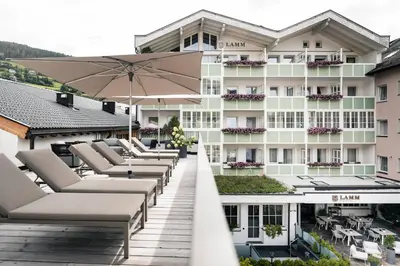 a row of lounge chairs on the roof of a hotel at Posthotel Lamm in Vipiteno