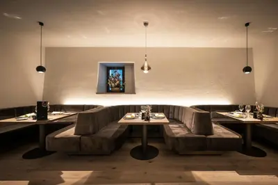 a restaurant with couches and tables in a room at Posthotel Lamm in Vipiteno