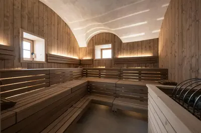 a church with wooden benches and windows at Posthotel Lamm in Vipiteno