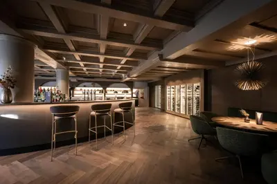 a bar in a restaurant with bar stools at Posthotel Lamm in Vipiteno