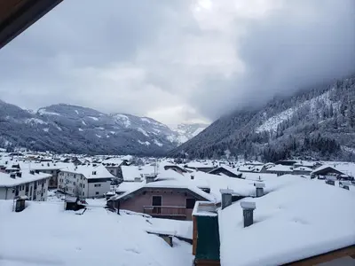 a village covered in snow with mountains in the background at Casa Bedovina in Predazzo