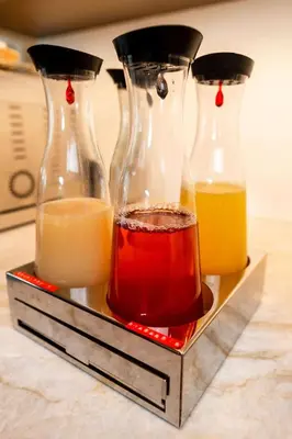 three glass vases filled with different types of liquid at Hotel Garni Günther in Postal