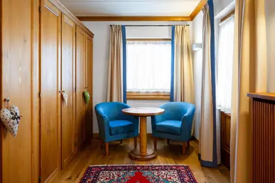 a room with two chairs and a table and a window at Hotel Natale in Cortina dʼAmpezzo