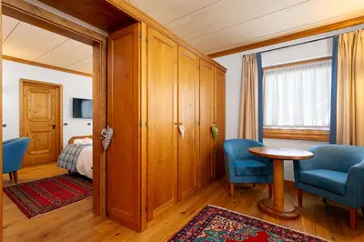 a bedroom with a bed and a table and chairs at Hotel Natale in Cortina dʼAmpezzo