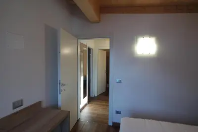 a room with a bed and a light on the wall at Casa Ciroch in Moena