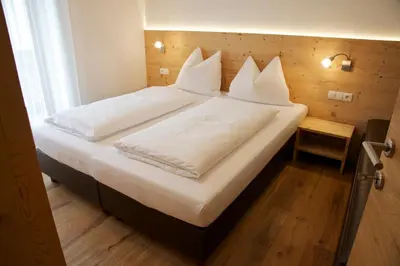 a large bed with white sheets and pillows on it at Appartements Mutschlechner in Valdaora
