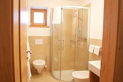 a bathroom with a shower and a toilet and a sink at Appartements Mutschlechner in Valdaora