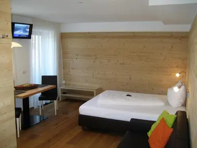 a hotel room with a bed and a desk at Appartements Mutschlechner in Valdaora