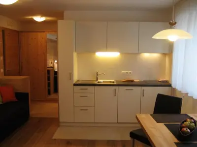 a kitchen with white cabinets and a sink at Appartements Mutschlechner in Valdaora