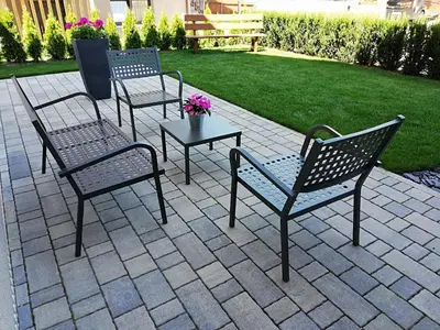 three chairs and a table on a patio at Appartements Mutschlechner in Valdaora