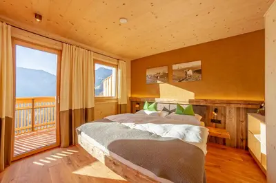 a bedroom with a bed and a large window at Thalhofer Hof in Lazfons