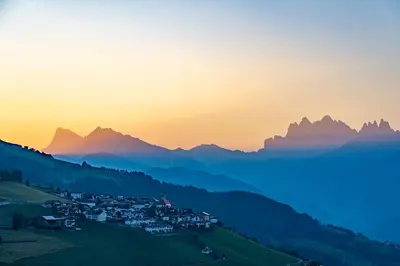 a village on a hill in the mountains at sunset at Thalhofer Hof in Lazfons