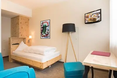 a bedroom with a bed and a table and chairs at Bed&Breakfast Pension Hilpold in Lana