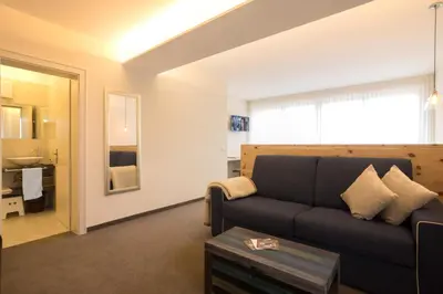 a living room with a couch and a bathroom at Bed&Breakfast Pension Hilpold in Lana