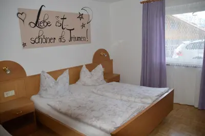 a bedroom with a bed with a sign on the wall at Haus Hofer in Barbiano