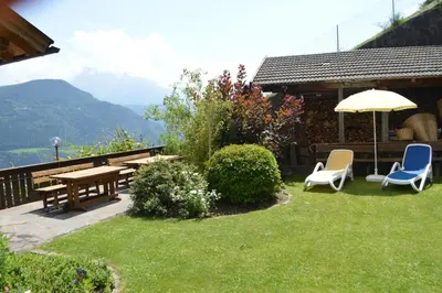 a patio with a table and chairs and an umbrella at Haus Hofer in Barbiano