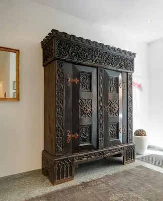 a wooden cabinet in a room with a mirror at Hotel Goldene Rose in Brunico