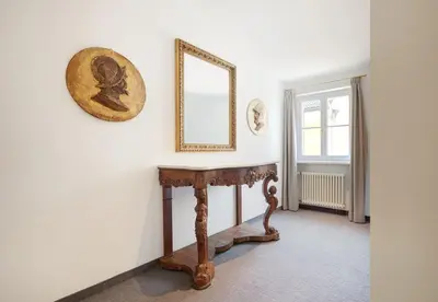 a room with a table and a mirror on the wall at Hotel Goldene Rose in Brunico
