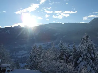 a snow covered mountain with the sun in the sky at Agriturismo Maso Santa Libera in Tesero