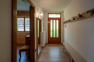 a hallway of a house with a table and a door at Casa del Salice in Carano