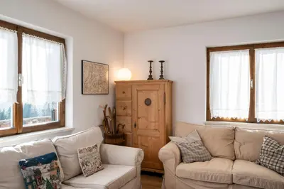 a living room with a couch and a chair and windows at Casa del Salice in Carano