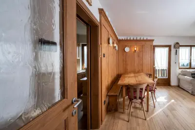 a kitchen with a wooden table and a dining room at Casa del Salice in Carano