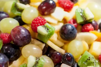 a pile of fruit salad with grapes and raspberries at Rösslwirt in Barbiano