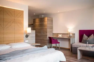 a hotel room with two beds and a desk at Rösslwirt in Barbiano