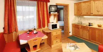 a kitchen with a table and a kitchen with a microwave at Residence Priska in Racines