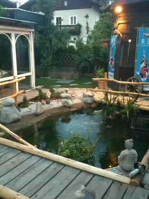 a koi pond in a yard with a wooden deck at Residence Priska in Racines
