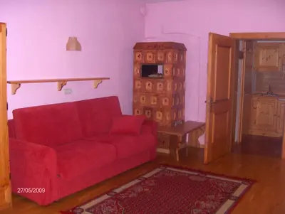 a living room with a red couch and a table at Residenze Sonnenschein in Villabassa