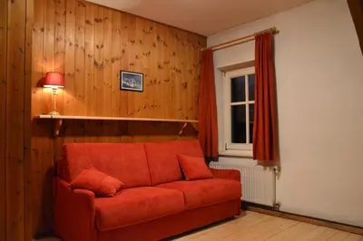 a living room with a red couch and a window at Residenze Sonnenschein in Villabassa