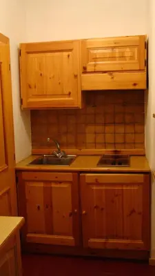 a kitchen with wooden cabinets and a sink at Residenze Sonnenschein in Villabassa