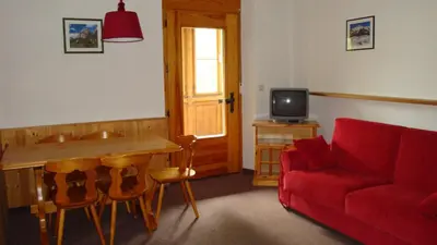 a living room with a red couch and a table at Residenze Sonnenschein in Villabassa