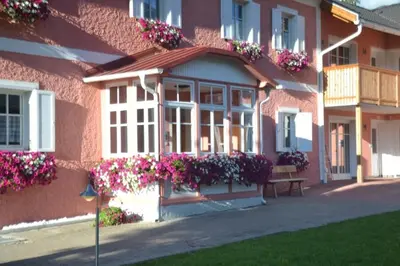 a pink building with flowers on the side of it at Residenze Sonnenschein in Villabassa